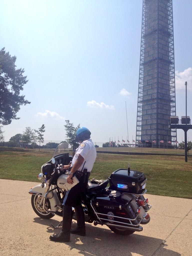 Cop getting ready to issue tickets to bikers illegally parked near the Monument