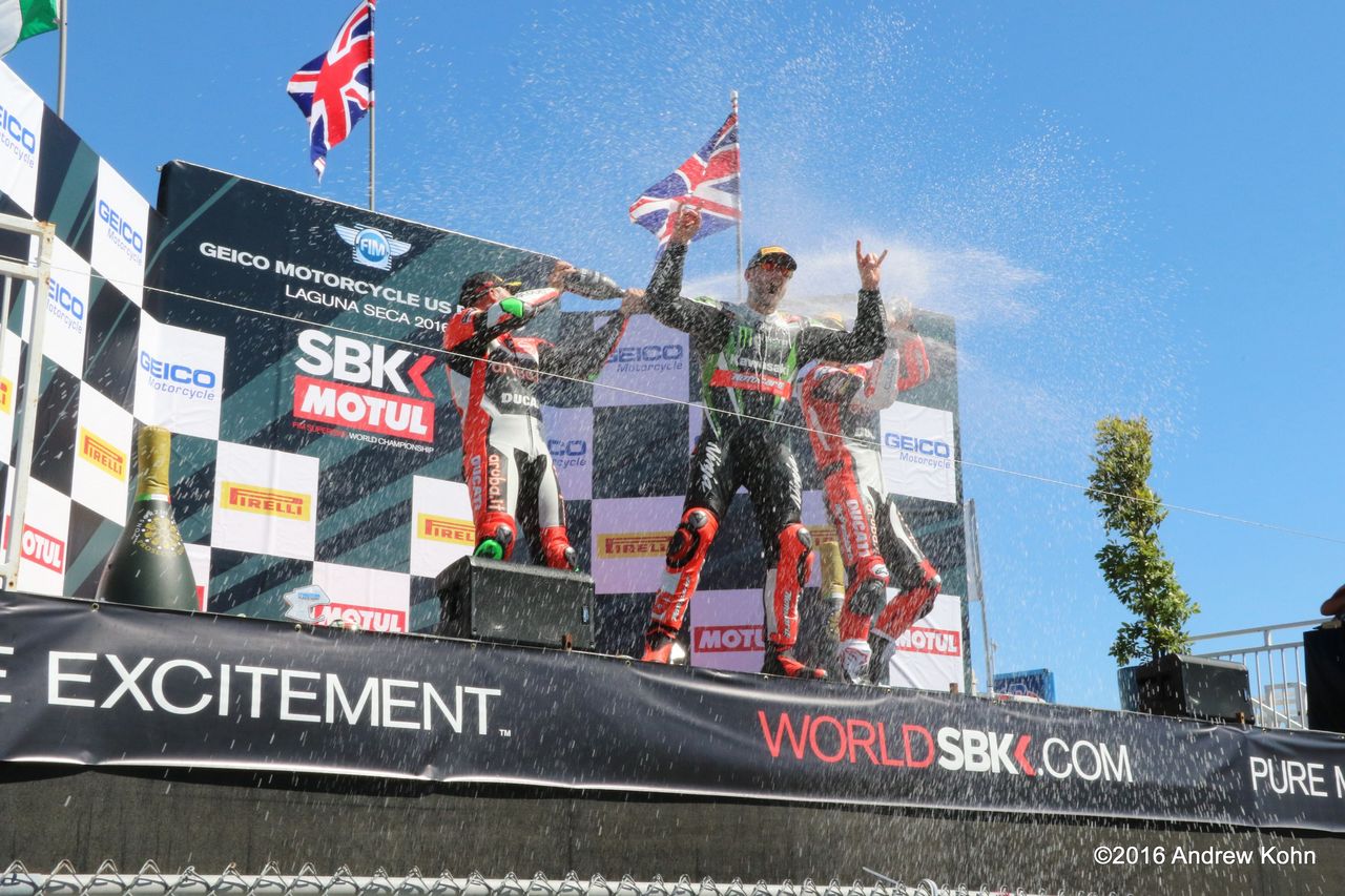 Tom Sykes taking a champagne bath on the podium