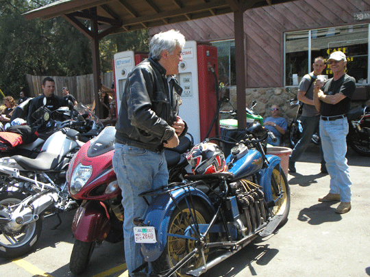 Jay Leno poses for a picture with his classic bike in front of Rock Store