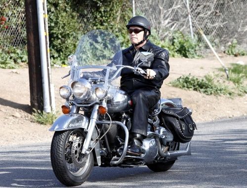 Arnold Schwarzenegger riding what looks like a Harley