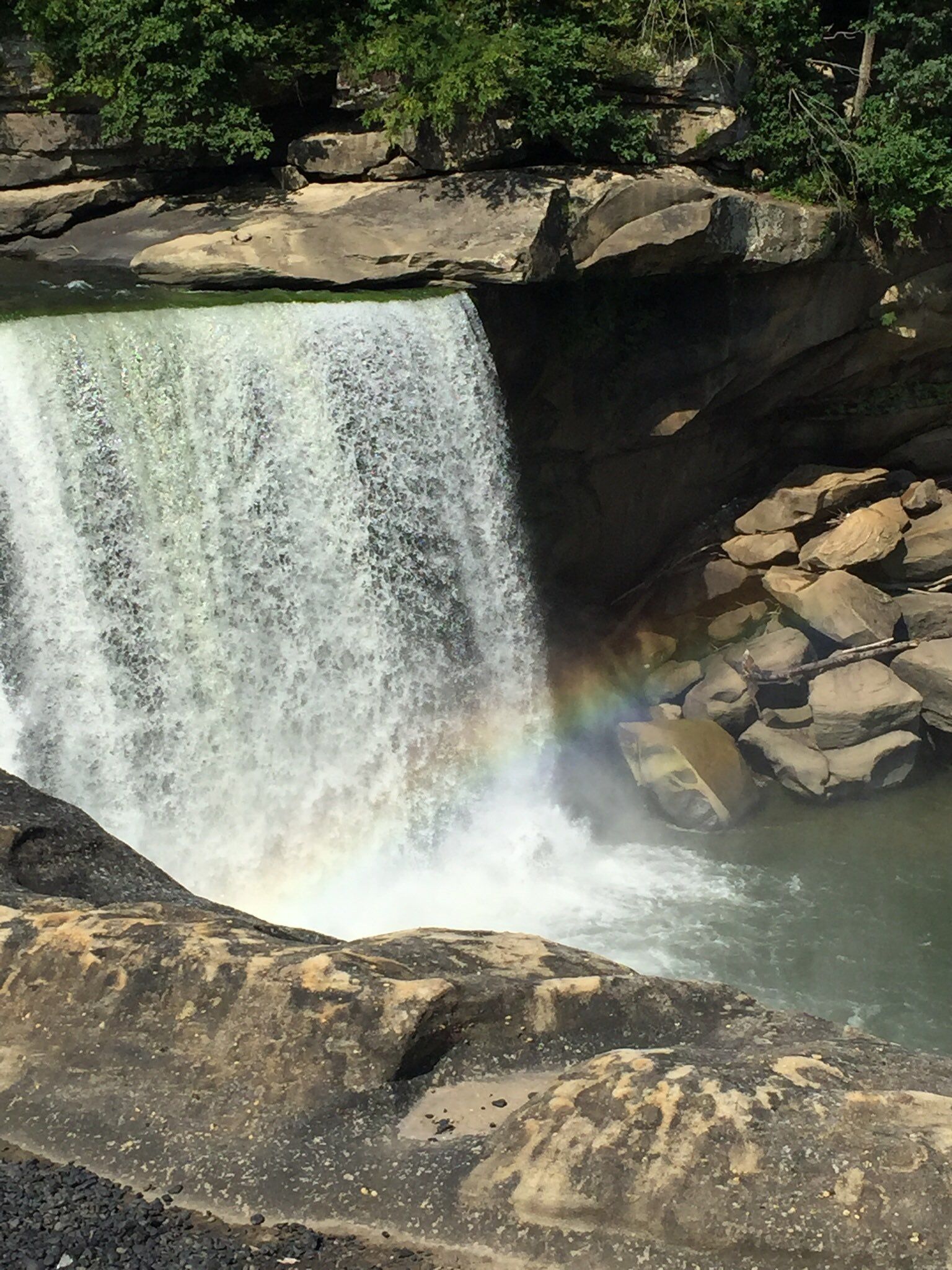 Small rainbow at the base of the falls